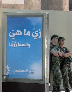 جنديان يحرسان إعلان إنتخابي أمس (هيثم الموسوي)