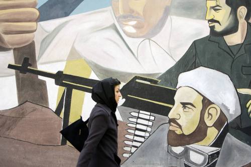 إيرانيّة تمرّ بجانب جداريّة في «ساحة فلسطين» في طهران أمس (رويترز)