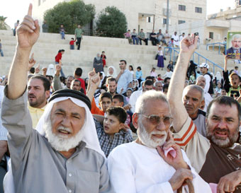 أردنيّون إسلاميّون يطلقون شعارات معارضة للنظام في مخيّم الحسين للاجئين الفلسطينيّين في عمّان الشهر الماضي (ماجد جابر - رويترز) 