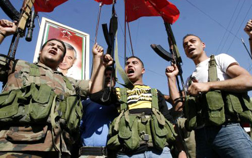 مسلّحون فلسطينيّون يهتفون ضدّ المؤتمر في مخيّم عين الحلوة جنوب لبنان أمس (علي حشيشو - رويترز)