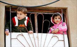 طفلان فلسطينيان على شرفة منزلهما في مخيّم شاتيلا في بيروت أمس (جمال صعيدي - رويترز)