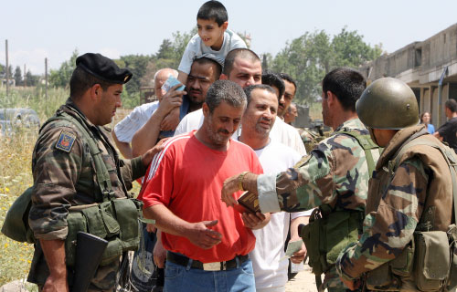 عناصر من الجيش اللبناني يدقّقون في أوراق النازحين الفلسطينيين من مخيم نهر البارد (وائل اللادقي)