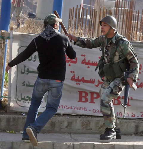أحد عناصر الجيش اللبناني يعترض أحد المتظاهرين خلال أحداث مار مخايل (هيثم الموسوي)