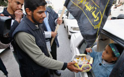 عنصر من «الجهاد الإسلامي» يوزّع الحلوى احتفالاً بمقتل جنديّين إسرائيليّين في غزّة أمس (محمد سالم - رويترز)