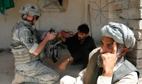 جندي أميركي يحاول الحصول على بصمات مواطن أفغاني (أرشيف ــ أ ب)