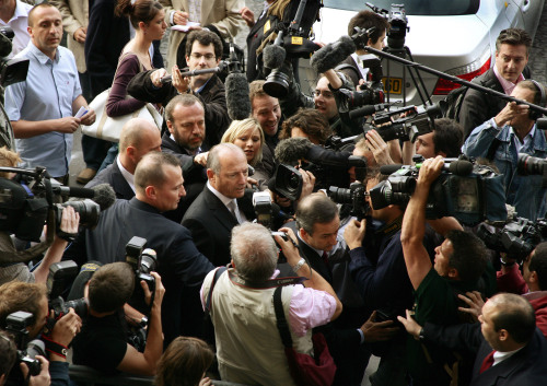مدير «ماكلارين مرسيدس» رون دينيس محاصراً بين الصحافيين لدى خروجه من جلسة الاستماع (أ ب)