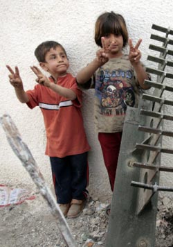 طفلان عراقيّان يرفعان راية النصر بعد إصابة آلية عسكرية أميركية في مدينة الصدر أمس (أحمد الربيعي ــ أ ف ب)