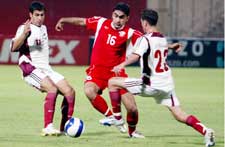 لاعب المحرّق علي عامر يحاول المرور بين عباس فضل الله ومحمد غدار في المباراة (أ ف ب)