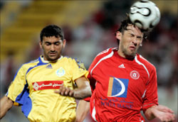 لاعب العربي الأوسترالي بوبوفيتش في صراع على الكرة مع لاعب الغرافة البحريني علاء حبيل (رويترز)