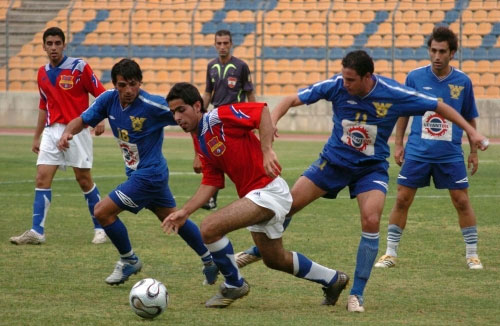 لاعب الريان علي بلوط يحاول حماية الكرة من لاعبَي الصفاء: طارق بايا (11) وحمزة عبود (18) تحت أنظار حسين طحان (محمد علي)