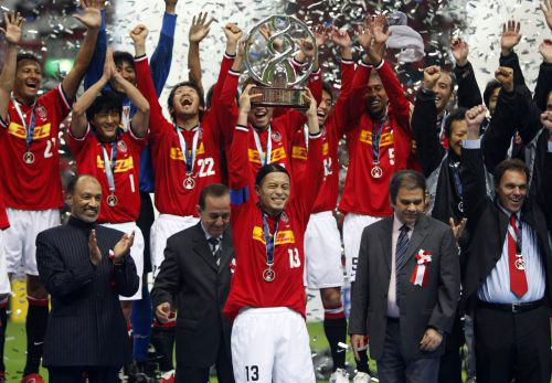 قائد فريق أوراوا يرفع كأس دوري أبطال آسيا، ويبدو بن همام رئيس الاتحاد الآسيوي (إساي كاتو ـ رويترز)