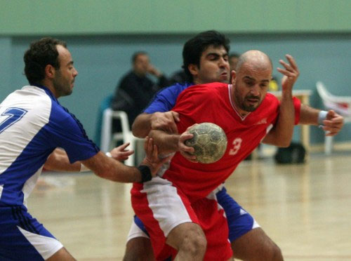 لاعب المشعل إسماعيل بني هاني يتعرض لكماشة دفاعية من هوليداي (محمد علي)