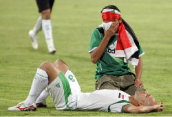 مشجع عراقي إلى جانب لاعب المنتخب باسم عباس وخيبة الخروج من التصفيات (ك. صاحب ــ أ ف ب)