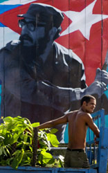 عامل كوبي يمرّ قرب صورة للزعيم كاسترو في هافانا (أدالبرتو روك ــ أ ف ب)