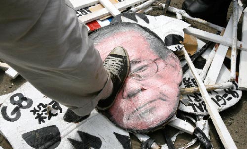 مناهض لقمّة «مجموعة الثماني» يدوس على صورة لفوكودا خلال احتجاج في هوكايدو في 9 من الشهر الجاري (لي جاي وون ــ رويترز)