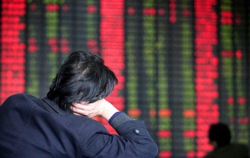 مستثمر يراقب حركة الأسهم وأسعارها في بورصة شانغهاي (يوجين هوشيكو ــ أ ب)