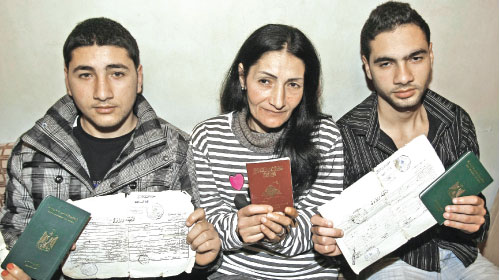 سميرة سويدان تحمل جواز سفرها اللبناني، وهي تتوسّط ابنيها محمّد وسمير أحمد المحرومين من الجنسيّة اللبنانيّة (أنور عمرو ــ أ ف ب) 