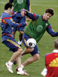 شابي ألونسو وأندريس إينييستا في صراعٍ على الكرة خلال تدريبات إسبانيا استعداداً للقاء السويد (أ ب)