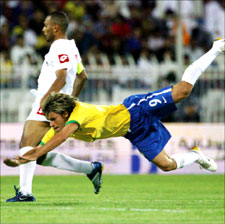 البرازيلي رافايل سوبيس يسقط على الأرض إثر اصطدامه بلاعب نادي الكويت جراح العتيقي (أ ب)
