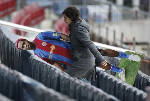 عاملة في ملعب «نو كامب» الخاص بنادي برشلونة الاسباني تنقل صورة لنجم الفريق البرازيلي رونالدينيو (رويترز)