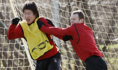 مهاجم مانشستر يونايتد واين روني (الى اليمين) ممازحاً زميله الكوري الجنوبي بارك جي سونغ في حصة تدريبية (رويتر