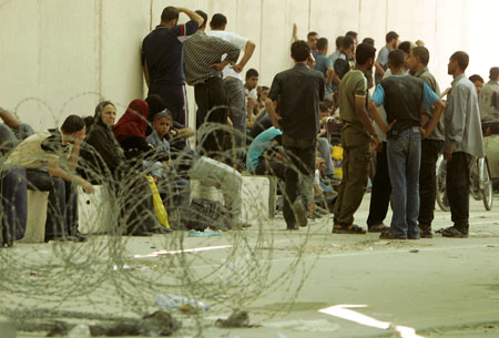 فلسطينيون ينتظرون العبور الى اسرائيل عبر معبر إريز في غزّة أمس (محمد سالم - رويترز)