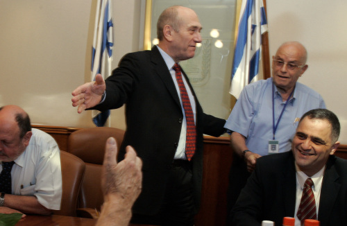 أولمرت خلال لقائه ناجين من المحرقة في مكتبه في القدس المحتلة أمس (سبستيان شناير - أ ب)