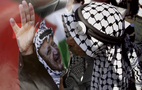 مناصر لحركة فتح يقبّل صورة الزعيم الفلسطيني الراحل ياسر عرفات في رام الله (أرشيف - أ ب)