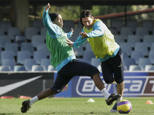 الأرجنتيني ليونيل ميسي متخطياً زميله البرازيلي رونالدينيو خلال تمارين فريقهما برشلونة (مانو فرنانديز ــ أ ب)