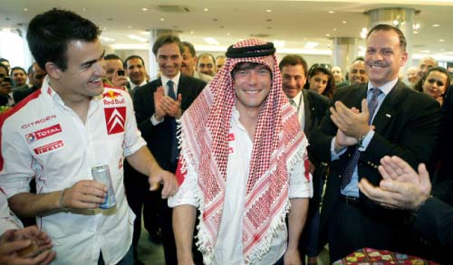 بطل العالم سيباستيان لوب بالكوفية الأردنية، وبدا إلى يساره الأمير فيصل بن الحسين، وإلى يمينه زميله في «سيتروين» داني سوردو (خاص الأخبار)