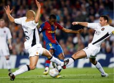 مهاجم برشلونة إيتو يحاول الاختراق بين مدافعي مانشستر فرديناند وبراون (آ. جيا ـ رويترز)