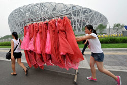 فتاتان تنقلان ملابس خاصة إلى ملعب «عش الطير» من أجل «بروفة» حفل الافتتاح (جو شان ـ رويترز)