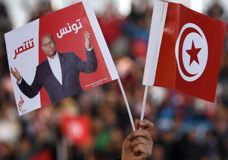 مناصر للمرزوقي يرفع شعار حملته والعلم التونسي (أ ف ب)