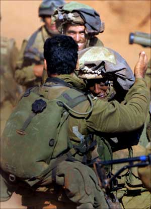 ضابط اسرائيلي يرحب بجنوده بعد عودتهم سالمين عند الحدود اللبنانية أمس (