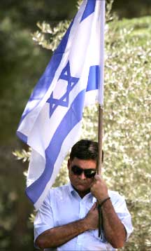 مستوطن يحمل العلم الاسرائيلي خلال تظاهرة ضد المسؤولين الإسرائيليين في القدس المحتلة أمس ( أب) 