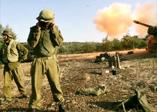 جندي إسرائيلي يغلق أذنيه خلال قصف على لبنان اوائل الشهر الجاري (أ ف ب)