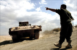 جندي اسرائيلي يوجه ناقلة جند قرب مستعمرة المنارة عند الحدود اللبنانية أمس ( أ ب)