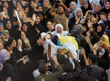 والد الشهيدة ميساء العثامنة يحمل جثمانها بين المشيعين في بيت حانون أمس (أ ب)