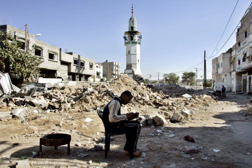 يجلس قرب أنقاض مسجد مهدّم في بيت حانون أمس (أ ب)