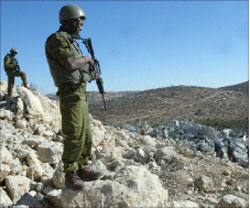 جنديان إسرائيليان يراقبان هدم أحد المنازل في الخليل أمس (أ ف ب)