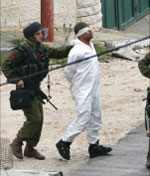 جنود إسرائيليّون يعتقلون فلسطينيّاً خلال عمليّة عسكريّة في نابلس أمس (أ ف ب)