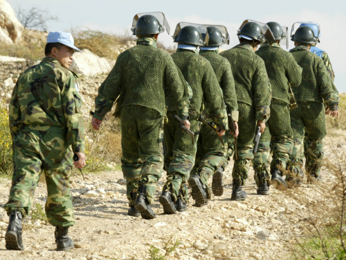 صينيون من القوات الدولية يجمعون القنابل العنقودية في القليلة جنوب لبنان (أرشيف - ا ب)