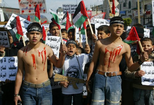 فتيان فلسطينيّون خلال احتجاج ضدّ الاقتتال الداخلي في مخيّم رفح في غزّة أمس (رويترز)