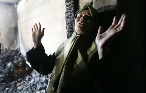 فلسطينيّة في منزلها الذي احترق بفعل الاشتباكات بين «فتح» و«حماس» في غزّة امس (رويترز)
