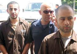 شرطيّ إسرائيلي يقتاد محمّد سرور (يمين) وماهر كوراني أمس (معاريف)