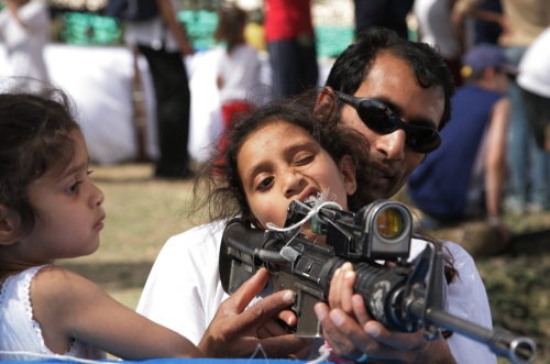 إسرائيلي يعلّم فتاة على استخدام بندقّيّة «أم - 16» في ذكرى قيام إسرائيل قرب مستوطنة معالي أدوميم أمس (غالي تيبون - أ ف ب)