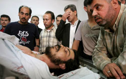 فلسطينيون حول جثة أبو جراد في غزّة أمس (حاتم موسى - أ ب)