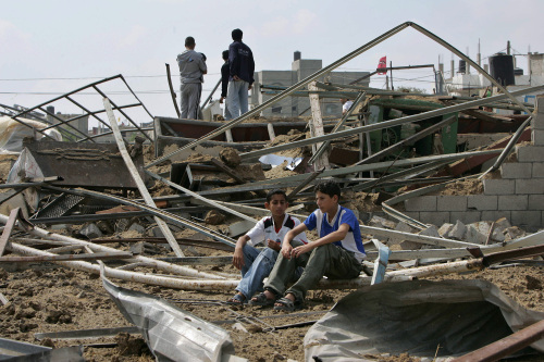 فتية فلسطينيون على انقاض منزل مدمر في غزة أمس (محمود حمس  - أ ف ب)