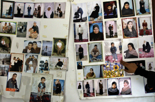 صور لمعتقلين فلسطينيين في السجون الإسرائيلية في جنين أمس (محمد بالاس - أ ب)