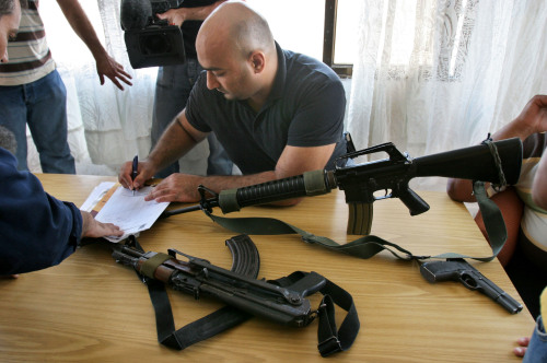 مقاوم فلسطيني يسلّم أسلحة في نابلس أمس (ناصر اشتاياه - أ ب)